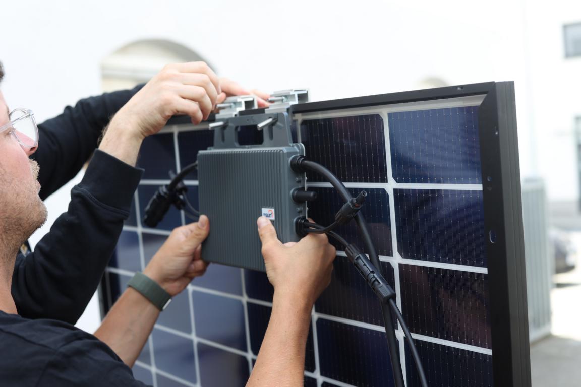 Der Wechselrichter wird mit Halterungen am Solarmodul verschraubt.